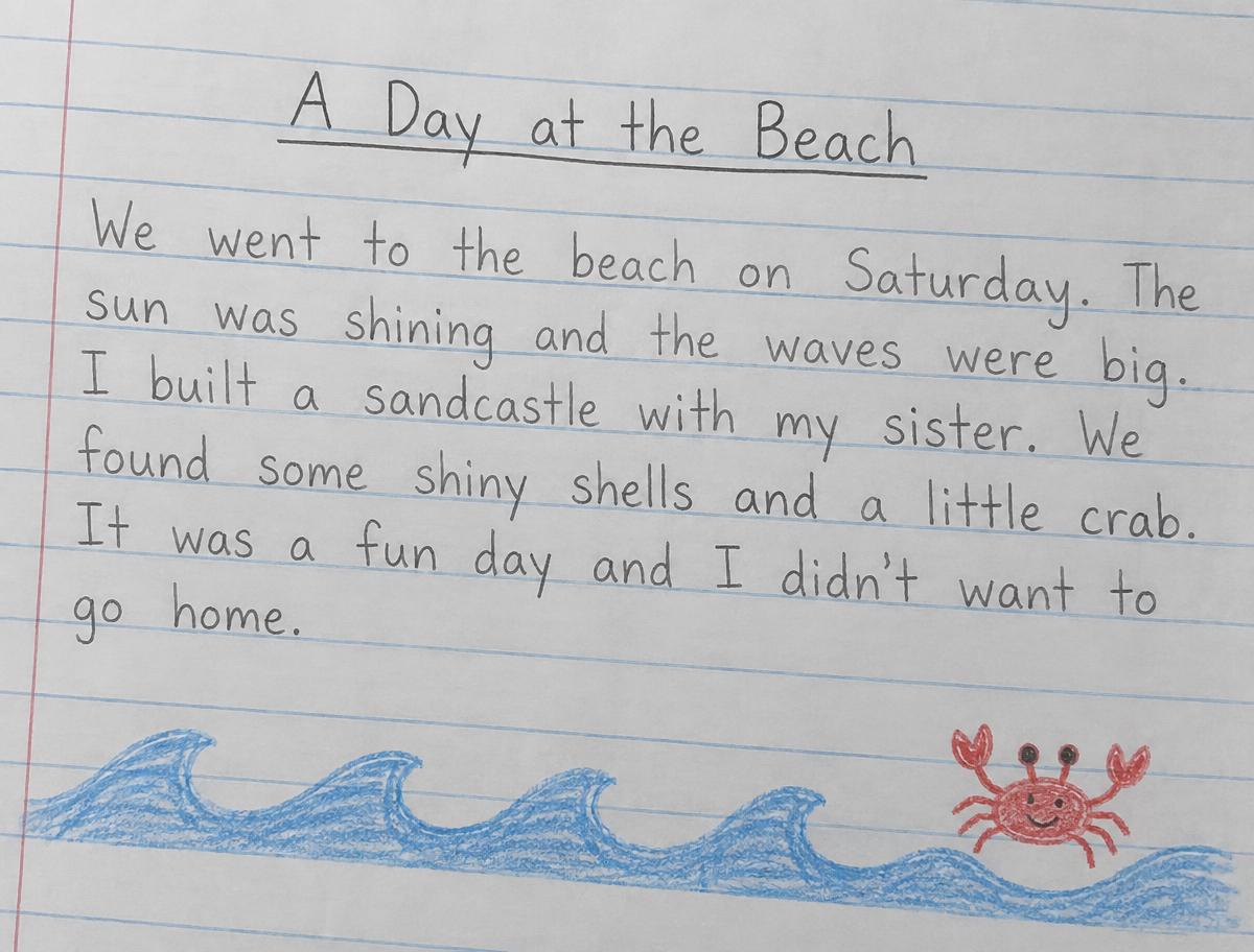 A child's handwritten story titled A Day at the Beach, with a crayon drawing of waves and a crab